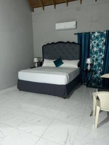um quarto com uma cama grande e cortinas azuis em Oak Villa Montego Bay 2 Entire em Montego Bay