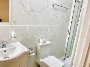 a bathroom with a toilet and a sink and a shower at London Studio Apartments Close to Station NP7 in London