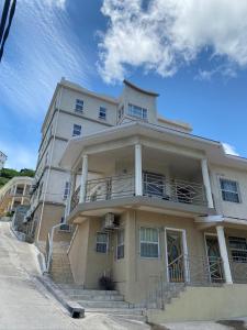 a large building with a staircase in front of it at SkylineSuites Lost in Paradise - FA4 in Grand Anse