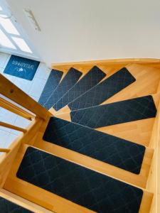 Una escalera en una habitación con alfombra negra en Ferienhaus JoNa - 4 Zimmer & 2 Bäder en Oberwesel