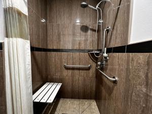 a shower with a bench in a bathroom at The Patio Motel - Los Angeles, LAX in Gardena