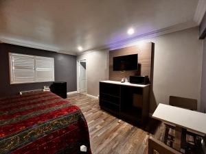 a hotel room with a bed and a flat screen tv at The Patio Motel - Los Angeles, LAX in Gardena +10 photos