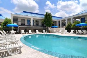 a resort pool with chairs and umbrellas at Baymont by Wyndham Macon I-75 in Macon