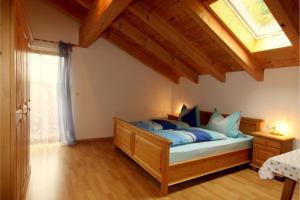 a bedroom with a bed with blue sheets and a window at Fluchthäusl in Berchtesgaden