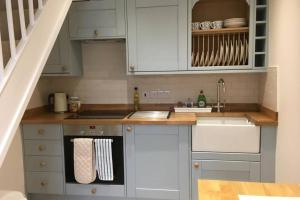 a kitchen with white cabinets and a counter top at Travershes Holiday Cottage in Exmouth