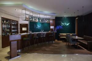 un bar en un restaurante con mesas y sillas en Best Western Premier Karsiyaka Convention & Spa Hotel, en Izmir
