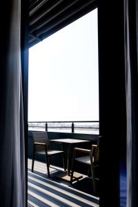 a table and chairs on a balcony with a view of the ocean at Best Western Premier Karsiyaka Convention & Spa Hotel in İzmir