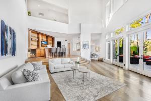 a living room with white furniture and large windows at Anzio Estate in Los Angeles