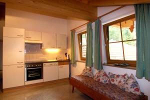 ein Wohnzimmer mit einem Sofa und einer Küche in der Unterkunft Fluchthäusl in Berchtesgaden
