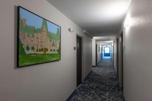 a hallway with a painting of a building on the wall at Rodeway Inn & Suites near Outlet Mall - Asheville in Asheville