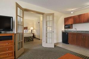 a hotel room with a kitchen and a bedroom at Baymont by Wyndham Macon I-75 in Macon