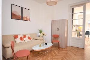 Castle Nest Apartment في بودابست: غرفة معيشة مع أريكة وطاولة وكراسي