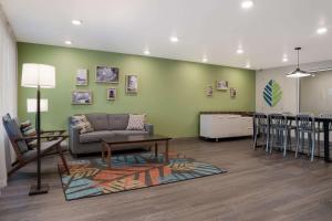 a living room with a couch and a table and a bar at WoodSpring Suites Detroit Sterling Heights in Sterling Heights