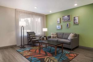 a living room with a couch and a table at WoodSpring Suites Detroit Sterling Heights in Sterling Heights