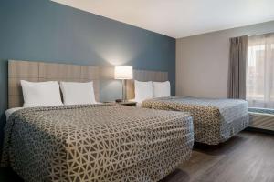um quarto de hotel com duas camas e uma janela em WoodSpring Suites Detroit Sterling Heights em Sterling Heights