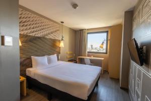 um quarto de hotel com uma cama grande e uma janela em ibis Tijuana em Tijuana