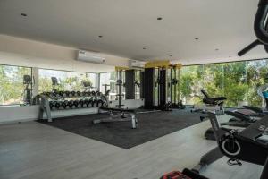 einen Fitnessraum mit Laufbändern und Trainingsgeräten in einem Gebäude in der Unterkunft Jade Tulum Zen Residences - Premium XL Apartment in Tulum