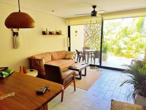ein Wohnzimmer mit einem Sofa und einem Tisch in der Unterkunft Jade Tulum Zen Residences - Premium XL Apartment in Tulum