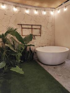 eine Badewanne im Bad mit Pflanzen und Lichtern in der Unterkunft Jade Tulum Zen Residences - Premium XL Apartment in Tulum