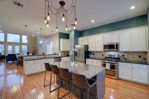 a kitchen with white cabinets and a table with chairs at Houston Townhome By George Brown Convention Center in Houston
