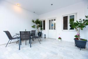 a patio with a table and chairs and plants at Emma's Airport Studio in Spáta