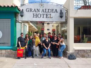 un grupo de personas posando para una foto frente a un hotel en Gran Aldea Hotel en Capilla del Monte