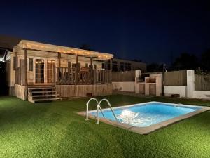 a small swimming pool in a yard at night at Chalet-home familiar "CAL ÍNDIA" "Pet friendly" in Sant Carles de la Ràpita