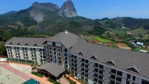 une vue aérienne d'un bâtiment avec une montagne en arrière-plan dans l'établissement Vista Azul Suites, à Vítor Hugo