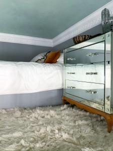 sypialnia z łóżkiem i szklaną komodą w obiekcie South Ken designer pad w Londynie