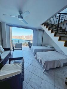 a hotel room with two beds and a balcony at Espectacular vista a la playa el Rodadero in Santa Marta
