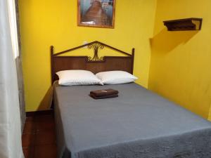 Una cama con dos almohadas y un bolso. en hotel posada Gutierrez antigua, en Antigua Guatemala