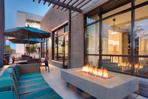 a fire pit in a patio with a couch and an umbrella at Hyatt Place Provo in Provo