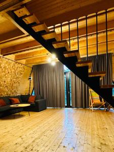 - un salon avec un canapé et un escalier dans l'établissement Collodi Cottages, à Tba