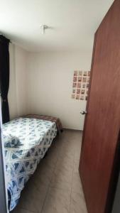a small room with a bed and a wooden door at Acogedor y Luminoso apartamento in Tunja