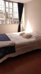 a bedroom with a large bed with a window at Acogedor y Luminoso apartamento in Tunja