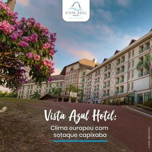 vistas a un hotel con un árbol y flores rosas en Vista Azul Suites, en Vítor Hugo