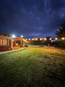 een achtertuin 's nachts met een huis en een zwembad bij Casa entre Viñas y Montaña in Mendoza