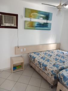 Apartamento em Ilhéus Pé na Areia في ايليوس: غرفة نوم صغيرة بها سرير ومروحة