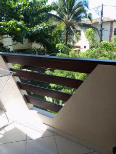 a balcony with a view of a palm tree at Apartamento em Ilhéus Pé na Areia in Ilhéus