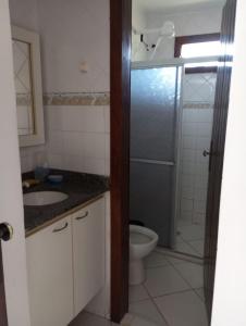 a bathroom with a shower and a toilet and a sink at Apartamento em Ilhéus Pé na Areia in Ilhéus