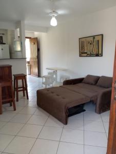 ein Wohnzimmer mit einem Sofa und einem Tisch in der Unterkunft Apartamento em Ilhéus Pé na Areia in Ilhéus