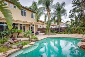 a swimming pool in front of a house with palm trees at Family-Friendly Manteca Vacation Rental with Pool! in Manteca