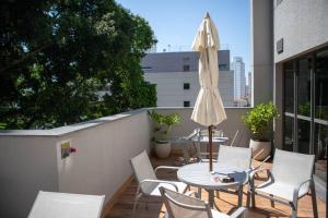 un patio avec des chaises, une table et un parasol dans l'établissement Blue Liberdade, à São Paulo
