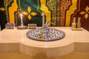 a bathroom sink with a candle on a counter at Maria Sahara Camp in Merzouga