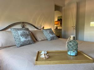Una cama con una bandeja de madera con un jarrón. en La Rosa dei Venti, en Santa Marinella