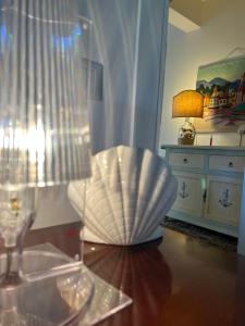 una camera con tavolo, sedia e lampada di La Rosa dei Venti a Santa Marinella