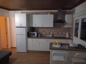 a kitchen with white cabinets and a white refrigerator at CASA DONELA in Hermigua