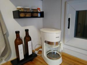 una cafetera y dos botellas de vino en una barra en Le volquet Mar de las Pampas en Mar de las Pampas