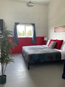 a bedroom with a bed with a red wall at The Shop@680 in Columbia Falls