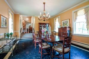 een eetkamer met een tafel en stoelen en een kroonluchter bij Historical Mansion 7BD Vacation Home in Derby City in Louisville